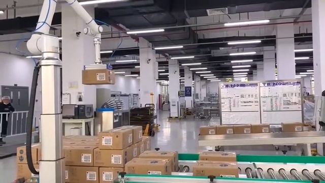 Робот-манипулятор с вакуумным захватом грузить коробки на поддон
