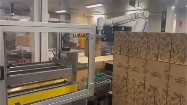 Робот-паллетайзер расставляет коробки с продукцией
