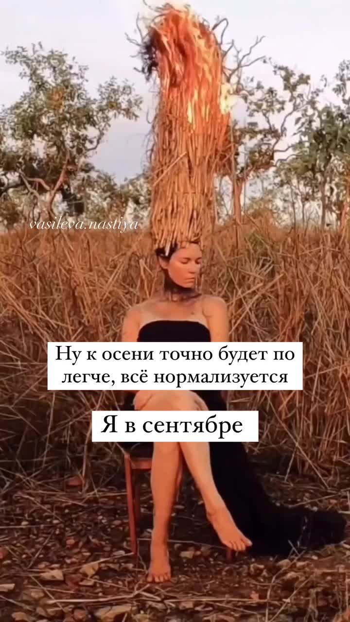 Девушка в черном платье сидит на стуле в поле с горящей травой на голове 🔥