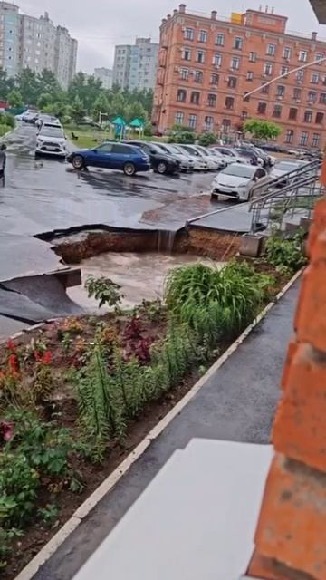 Асфальт провалился возле дома после дождя в Хабаровске на улице Крещенской