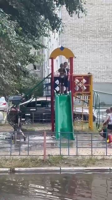 В Тюмени после ливней детская площадка ушла под воду. Тем временем дети устроили там мини-аквапарк.