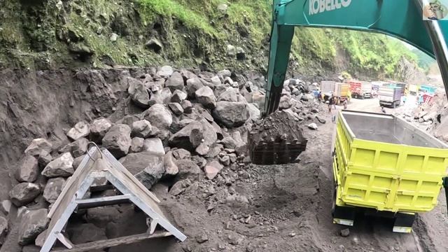 Строительство, экскаватор копает  чёрный песок