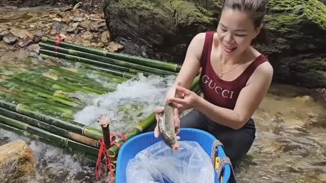 Рыбаки завидуют Юная девушка бамбуком наловила корзину рыбы в ручье Женская рыбалка