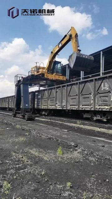 Поднятый экскаватор CAT320 с мобильным портальным шасси для разгрузки материалов на железнодорожной