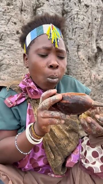 Женщине из африканского племени нравится еда на костре