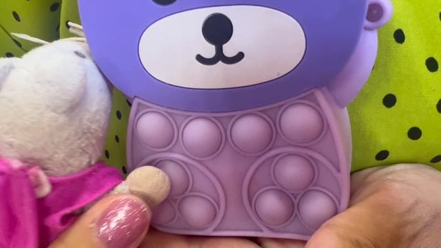 Буша показывает модную  девчачью сумочку с POP IT