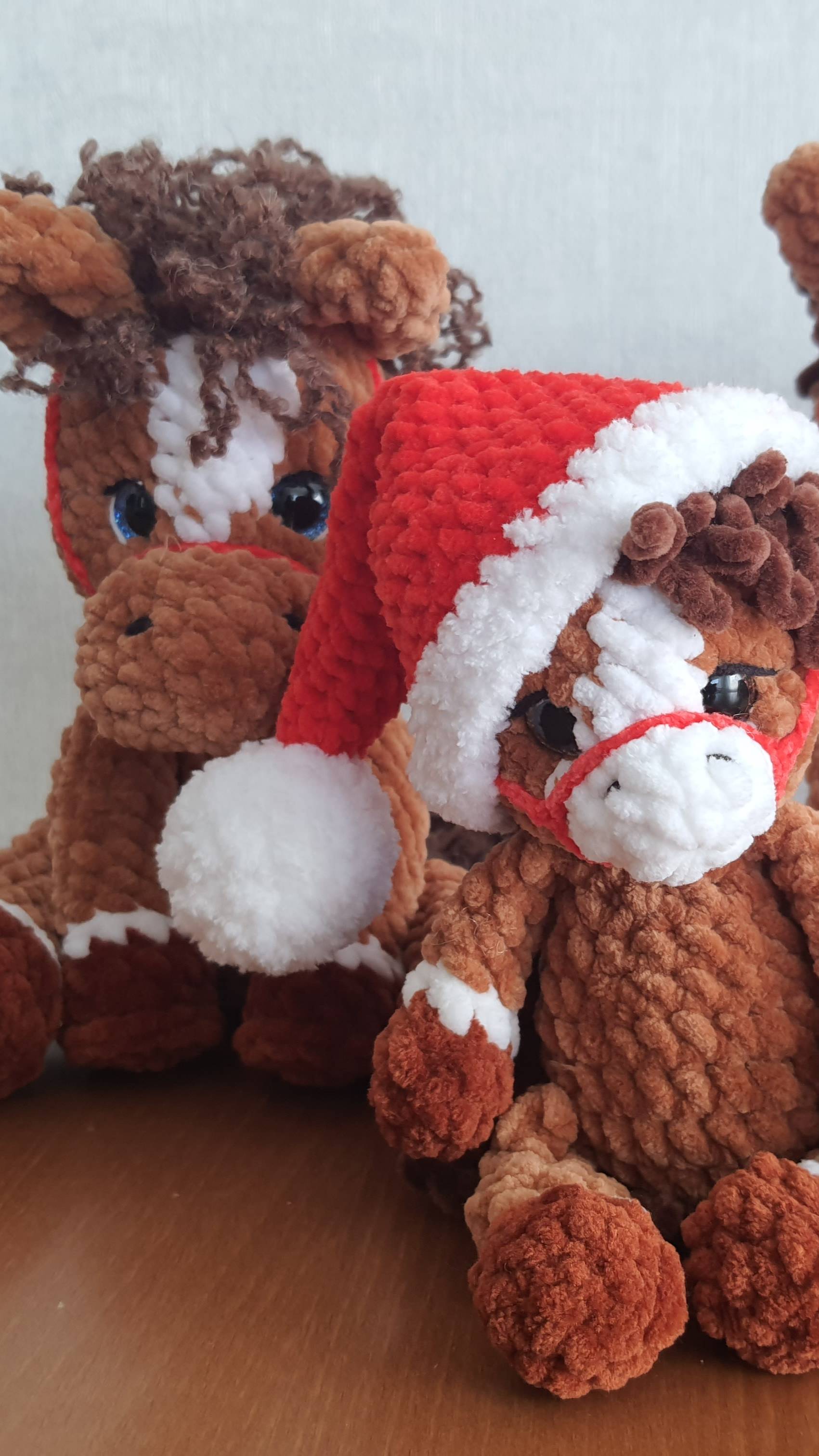 Много вязаных плюшевых лошадок.