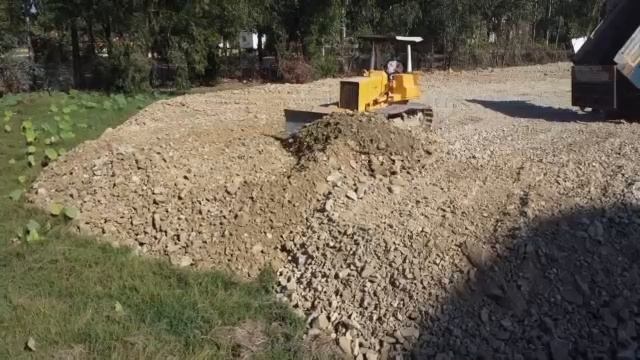 работ по засыпке каменистого грунта грузовиком 10kip и бульдозером KOMATSU на полевом озере Ep3