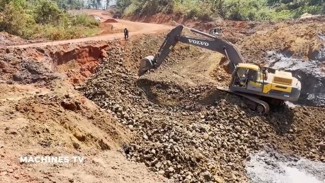 Экскаваторы и бульдозер работают над осушением и засыпкой водоема.