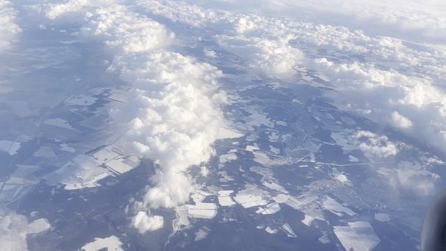 Сквозь облака видна поверхность земли.