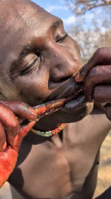 Охотник племени приготовил рёбрышки на костре