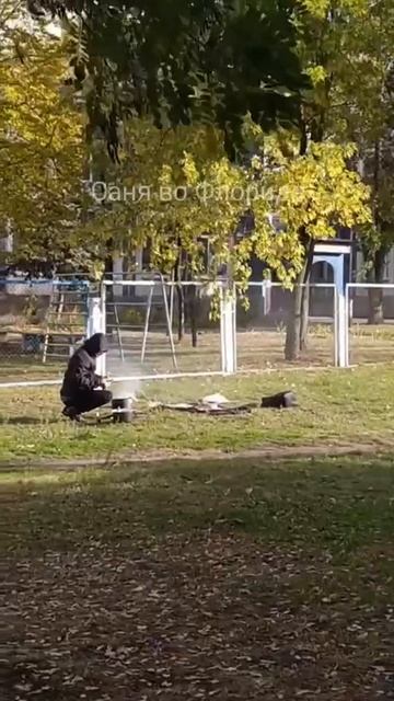 В Киеве хлопец готовит еду на улице на костре.