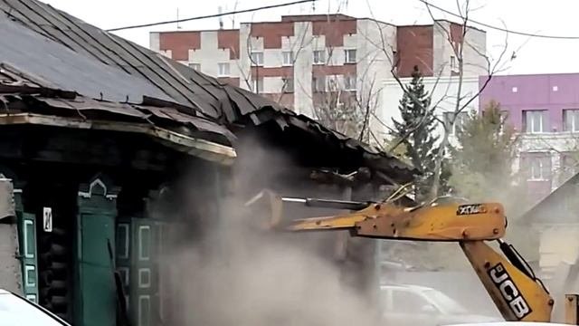 Демонтаж дома. Ювелирная работа экскаватора рядом с авто