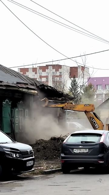Демонтаж дома. Ювелирная работа экскаватора рядом с авто