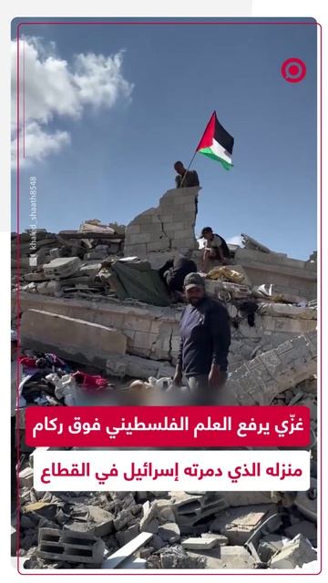 مواطن غزّي يرفع العلم الفلسطيني فوق ركام منزله المدمر في القطاع