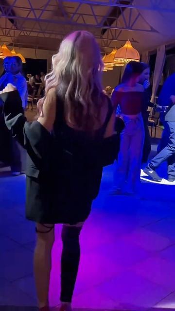 Красивая блондинка танцует в клубе на высоких каблуках