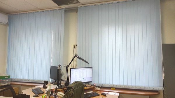Вертикальные жалюзи василькового цвета для оформления оконных проемов в офисном помещении.