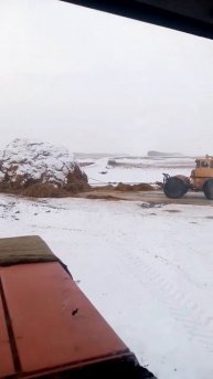 Трактора тянут стог сена.