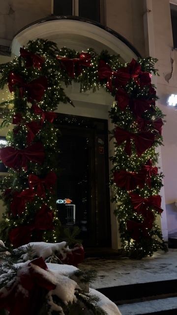 Оформление входной группы магазина гирляндами и еловыми ветвями