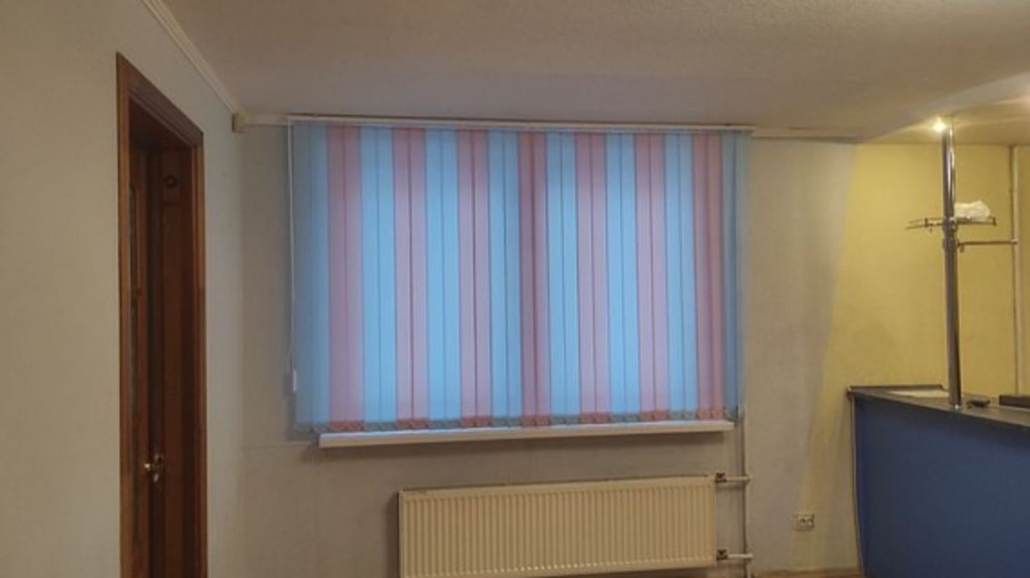 Вертикальные жалюзи с чередованием ламелей создали оригинальный декор окнам в комнате.