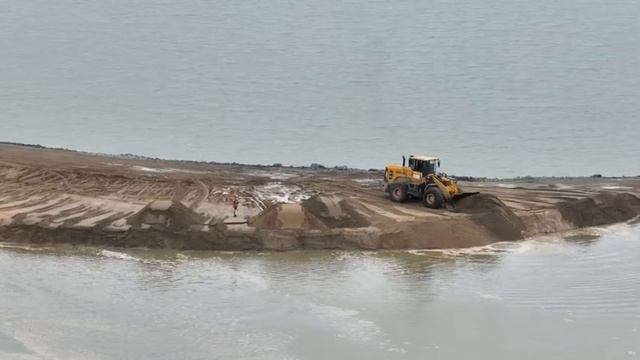 Потрясающий оператор бульдозера и колесного погрузчика, Который с силой толкает Песок по воде