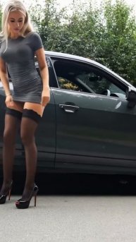 Девушка вышла с машины с красивой фигурой в чулках на каблуках