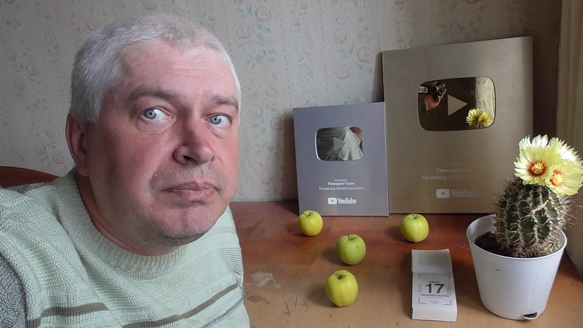 Я в комнате за столом. На столе: яблоки, календарь, кактус и мои награды Геннадий Горин