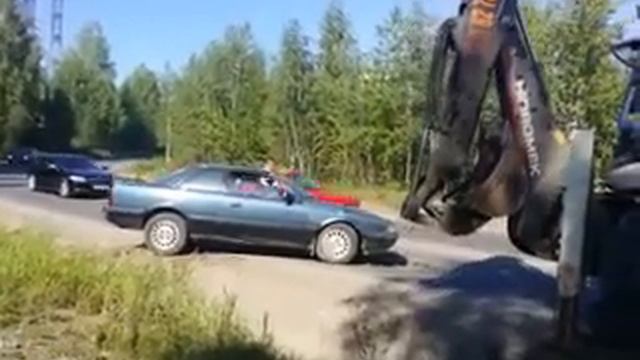 Трактор вытаскивает мазду из кювета