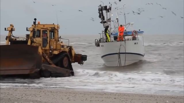 Бульдозер вытаскивает корабль на берег