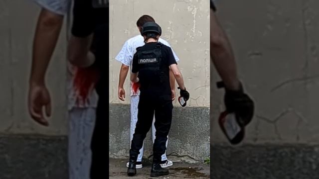 На видео сотрудник полиции Украины обливает из пакета с кровью человека во врачебном халате.