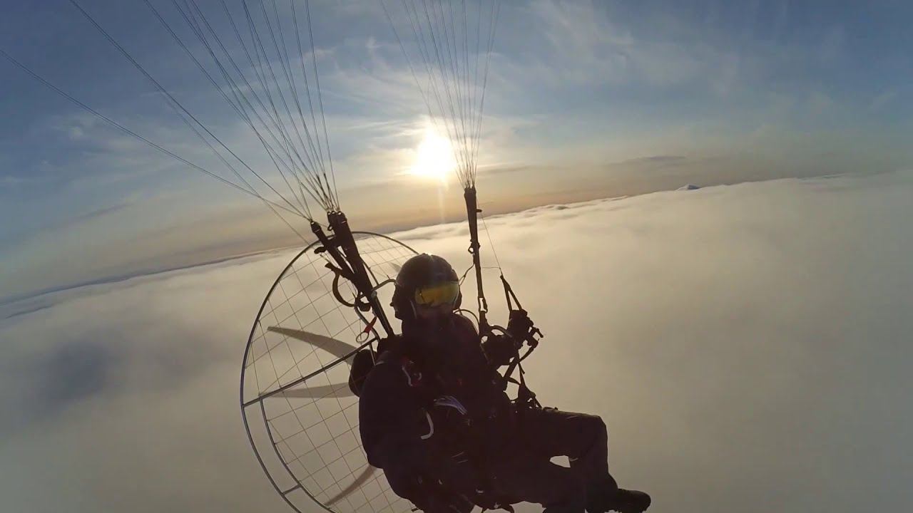 Параплан с мотором, полёт над облаками. Paraglider with a motor, flying over the clouds. Paramotor.