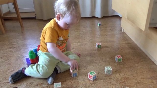 Арсений учит буквы в игре с кубиками.