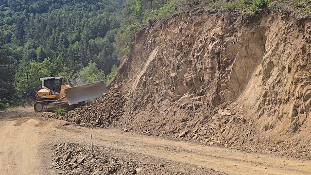 Строительство, расширяем горную дорогу срезаем склон