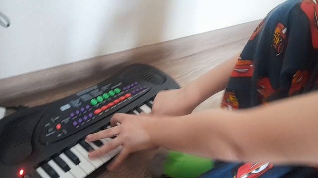младший брат учит играть на синтезаторе