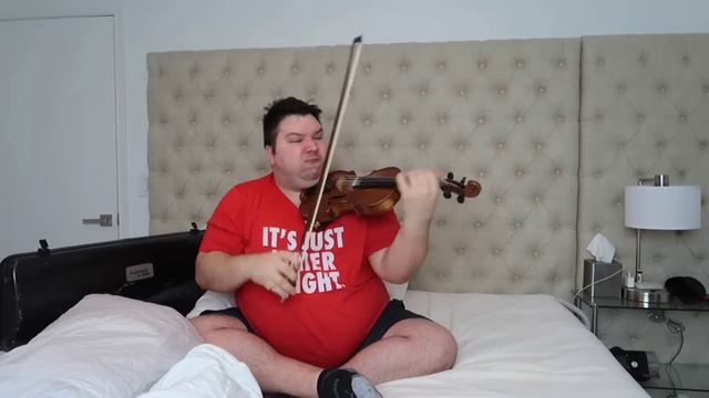 nikocado playing the violin on his bed
