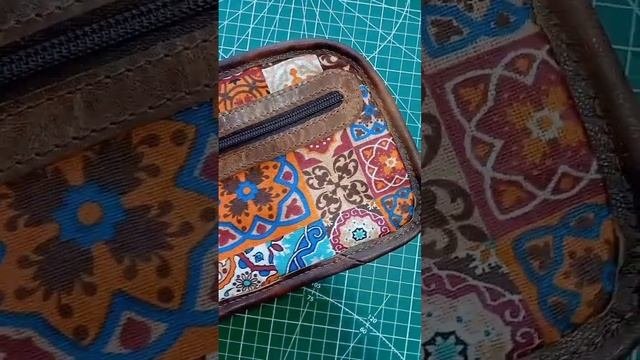 В работе маленькая сумочка из двух цветов кожи.