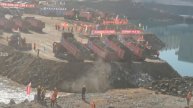 Dozens of dump trucks dumped rocks to cut off the river.The shocking construction site