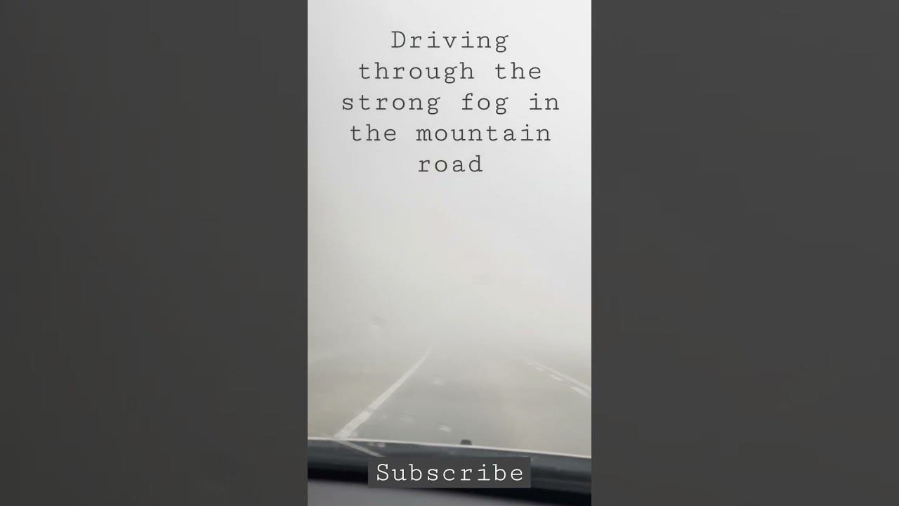Driving through the strong fog in the mountain road