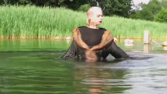 A girl swimming in a fur coat, jeans and shoes