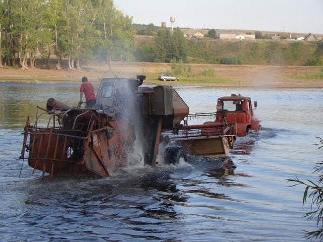 Tractor T-150K pulls Harvester SK-5 Niva through a deep river. Dangerous crossing!