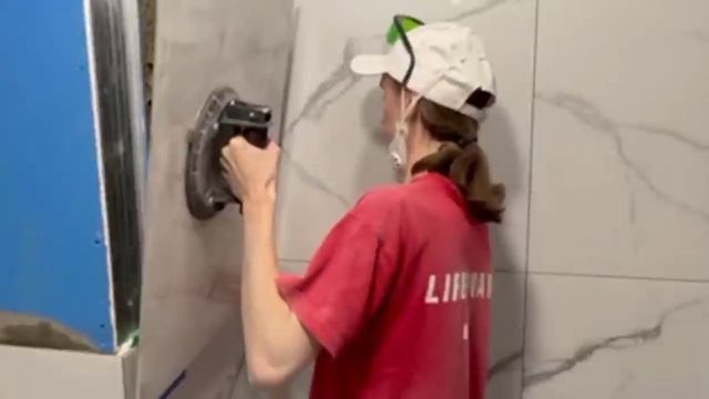 Девушка кладет плитку