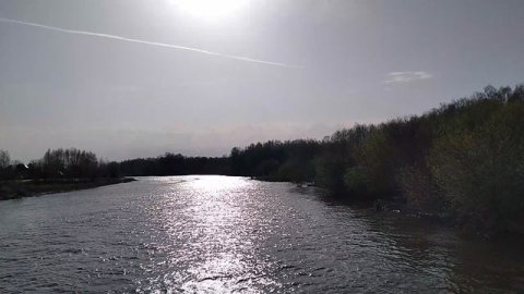 Красиво блестят лучи весеннего солнца в отражении воды на реке Клязьма во время половодия