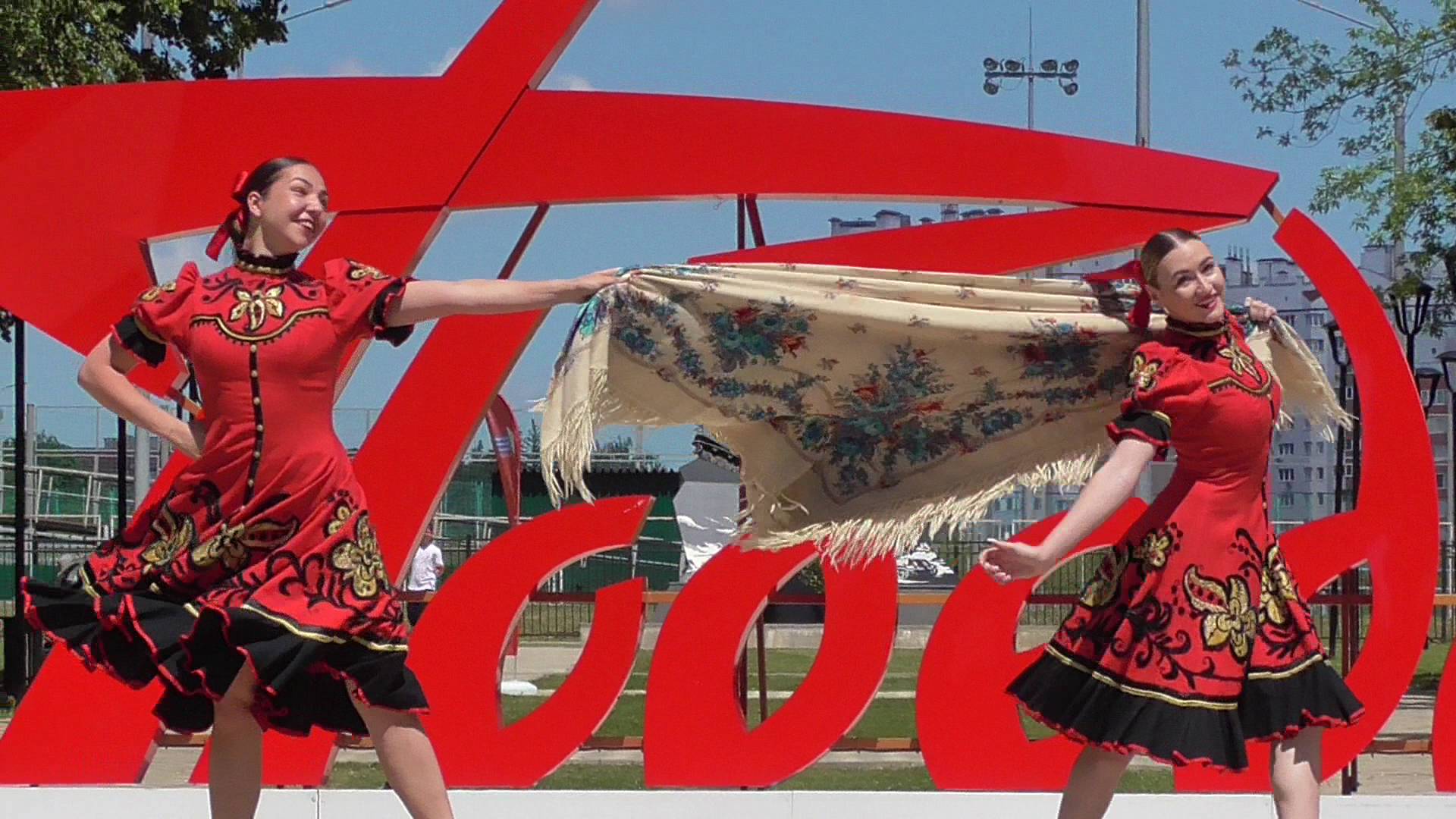 Две девушки танцуют танец с платками в парке. Парк Победы
