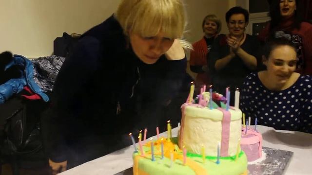 Именинница задувает свечи на праздничном торте