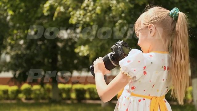 Little girl with camera in a green park