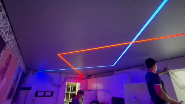 Серый натяжной потолок с двумя переплетающимися RGB световыми линиями
