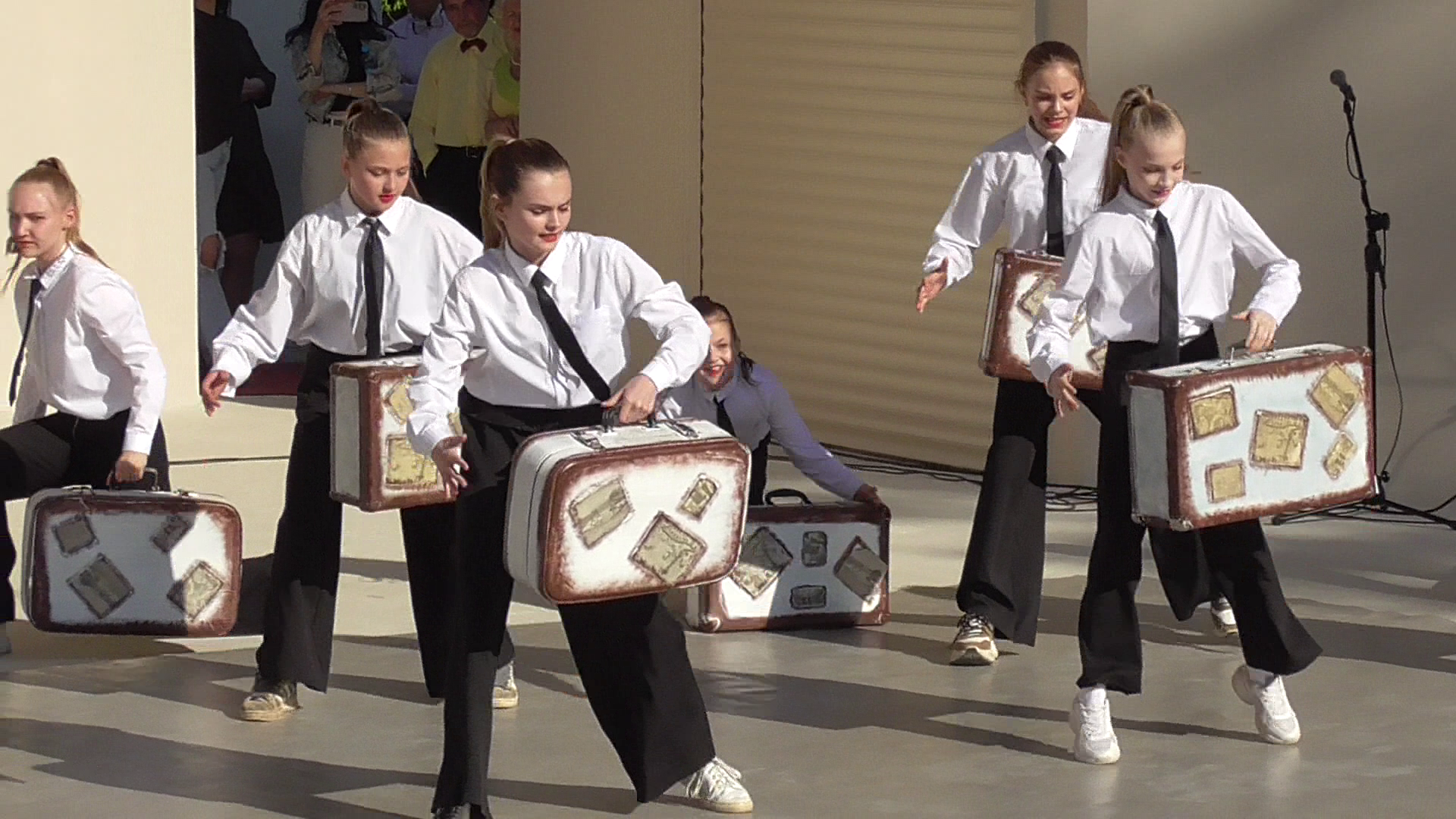 Танцевальный коллектив танцует танец с чемоданами
