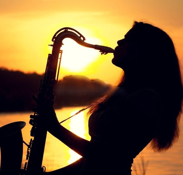 Красивая девушка играет на саксофоне