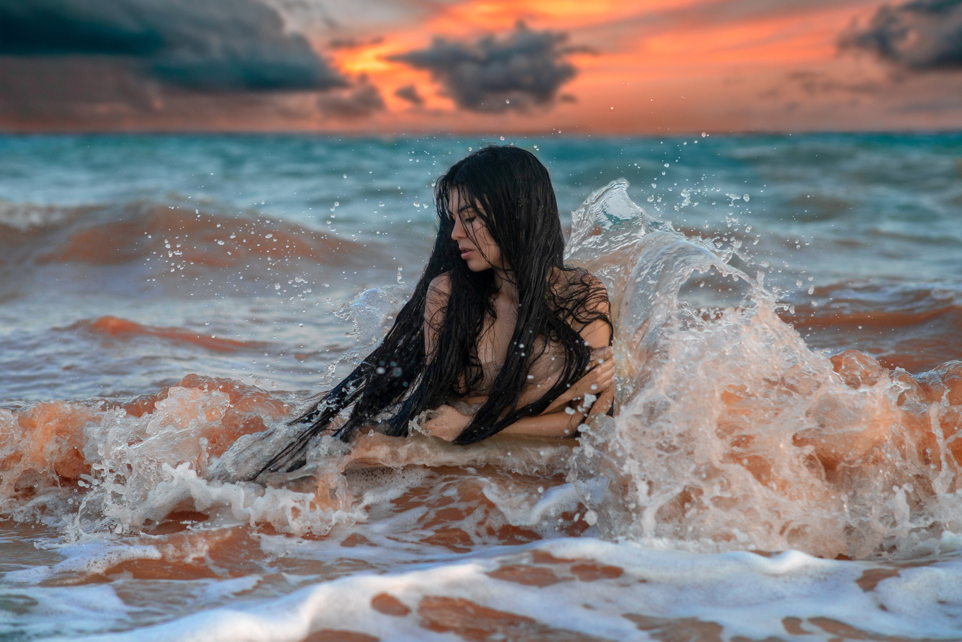 Молодая обнажённая девушка на берегу моря