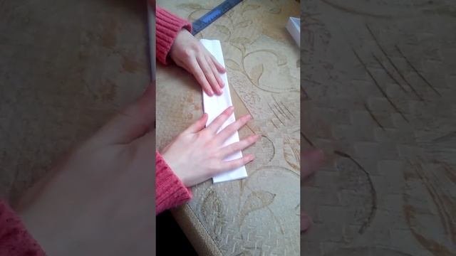 Показывает как делать оригами пистолет